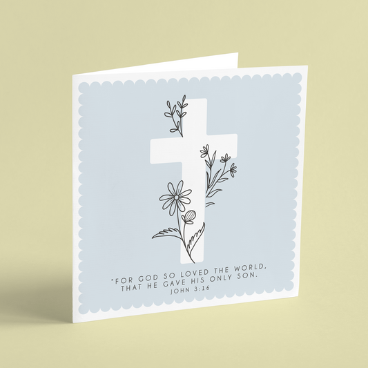 A square Easter card featuring a white cross on a blue background illustrated with floral outlines and reading 'For god so loved the world, that he gave his only son. John 3:16'.