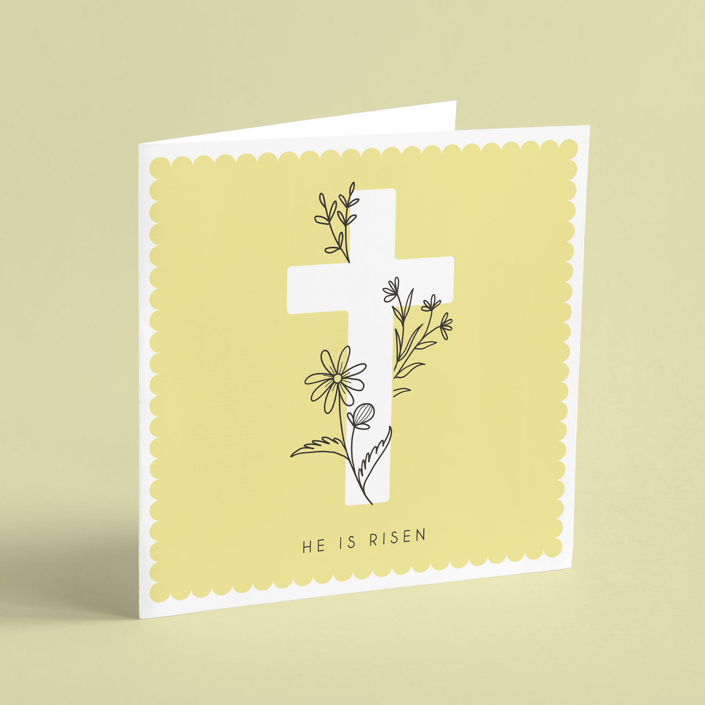 A square Easter card featuring a white cross on a yellow background illustrated with floral outlines and reading 'He is Risen'.